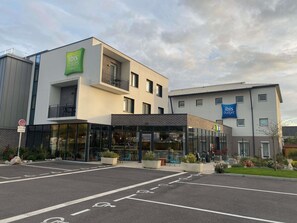 A modern hotel with a glass facade, a balcony, and a sign for 'ibis Styles Hotels'. - Ibis Styles Le Treport Mers Les Bains (Mers-les-Bains)
