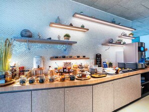 Una cocina moderna con una encimera amplia, diversos alimentos y electrodomésticos.