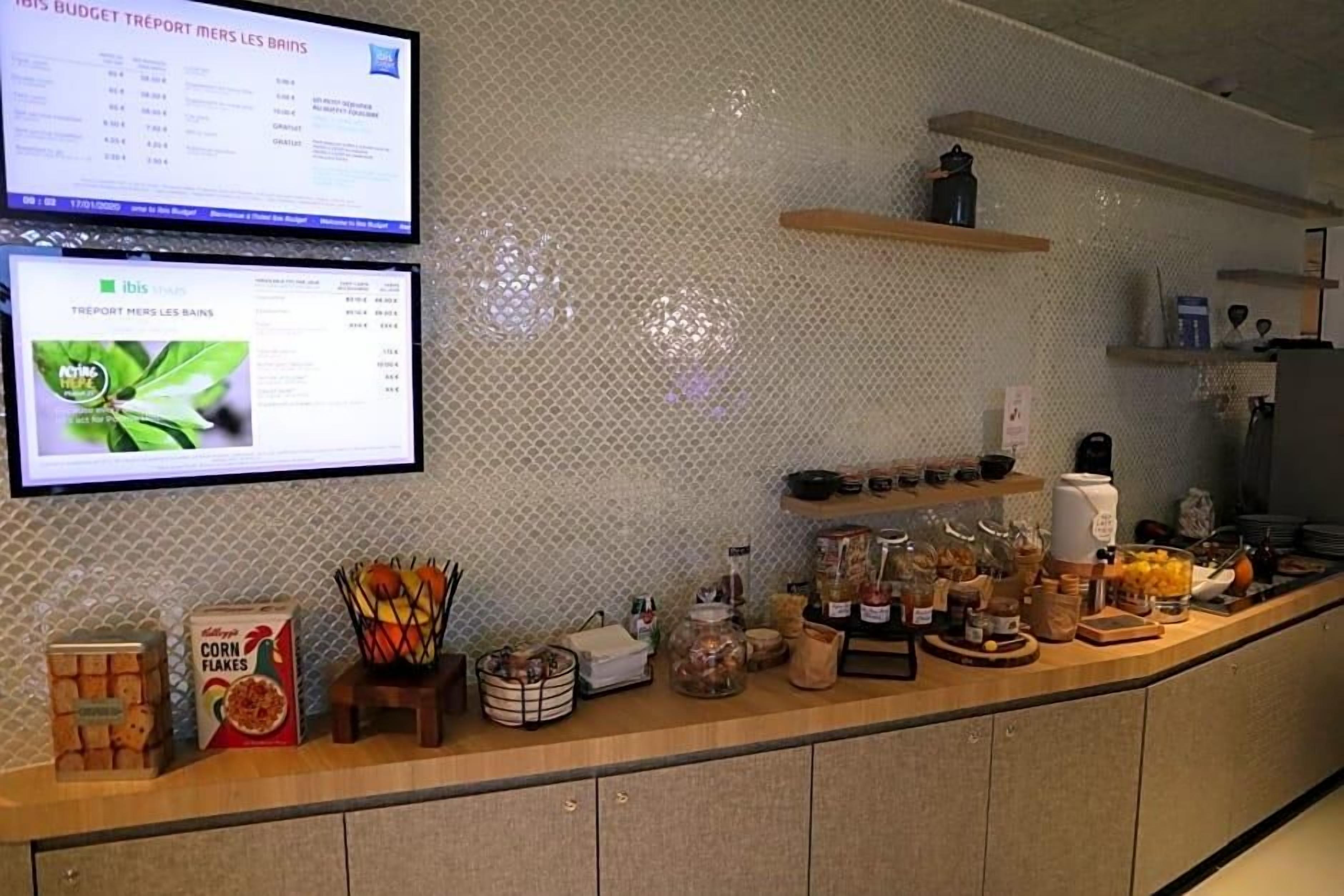 A kitchen counter with various food items and a computer displaying a budget report.