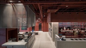 Un intérieur moderne comprenant un espace cuisine, un coin salon et une présentation d’objets décoratifs.