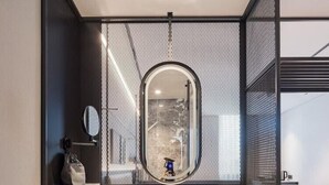 Une salle de bain moderne avec un grand miroir, un lavabo et un porte-serviettes.