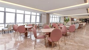A spacious dining area with marble flooring, pink chairs, and large windows providing natural light. - Guangzhou Tianhe Sports Center Mercure Hotel (Guangzhou)