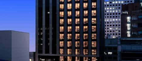 A tall, modern hotel building with illuminated windows and a prominent sign reading "G3 HOTEL".