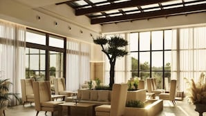 Ein geräumiges Wohnzimmer mit großem Fenster, einem zentral platzierten Baum und mehreren Sitzgruppen.
