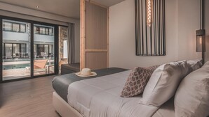 A modern hotel room with a large bed, a view of a pool, and a balcony. - Cavo Suites - Adults Only (Zakynthos)