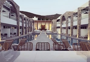 A poolside area with lounge chairs and a clear view of the pool. - Cavo Suites - Adults Only (Zakynthos)