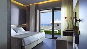 A modern hotel room with a large bed, a small bedside table, a mirror, and a view of the sea through a sliding glass door. - Nema Design Hotel and Spa - Adults Only (Hersonissos)