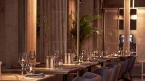 A restaurant with long wooden tables, grey upholstered chairs, and a warm ambient lighting. - Nema Design Hotel and Spa - Adults Only (Hersonissos)