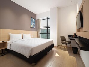 A hotel room with a bed, a desk, a chair, a TV, and a window. - Hotel 88 Blok M (Jakarta)
