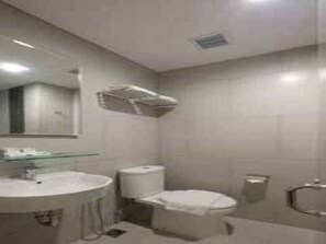 A bathroom with a round sink, a toilet, a mirror, and a towel rack. - Hotel 88 Blok M (Jakarta)