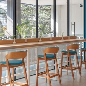 A bar area with wooden chairs and a long counter. - Hotel 88 Blok M (Jakarta)