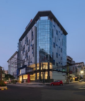 A modern building with a glass facade, multiple floors, and a prominent entrance. - Hotel 88 Blok M (Jakarta)