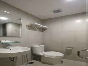 A bathroom with a round sink, toilet, and a mirror. - Hotel 88 Blok M (Jakarta)