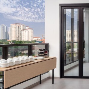 A modern apartment with a balcony, a coffee maker, and a view of high-rise buildings. - Hotel 88 Blok M (Jakarta)