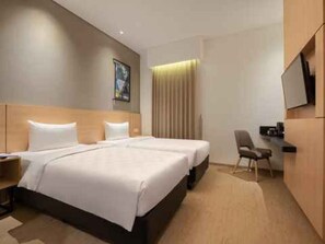 A hotel room with a double bed, a desk, a chair, a television, and a window with curtains. - Hotel 88 Blok M (Jakarta)