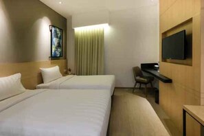 A hotel room with two beds, a desk, a chair, a television, and a painting on the wall. - Hotel 88 Blok M (Jakarta)