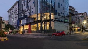 A modern building with a glass facade, multiple floors, and a prominent entrance. - Hotel 88 Blok M (Jakarta)
