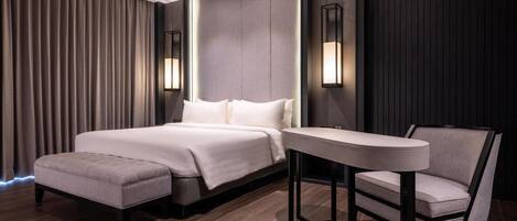 Habitación de hotel moderna con una cama grande, una mesita y una silla.