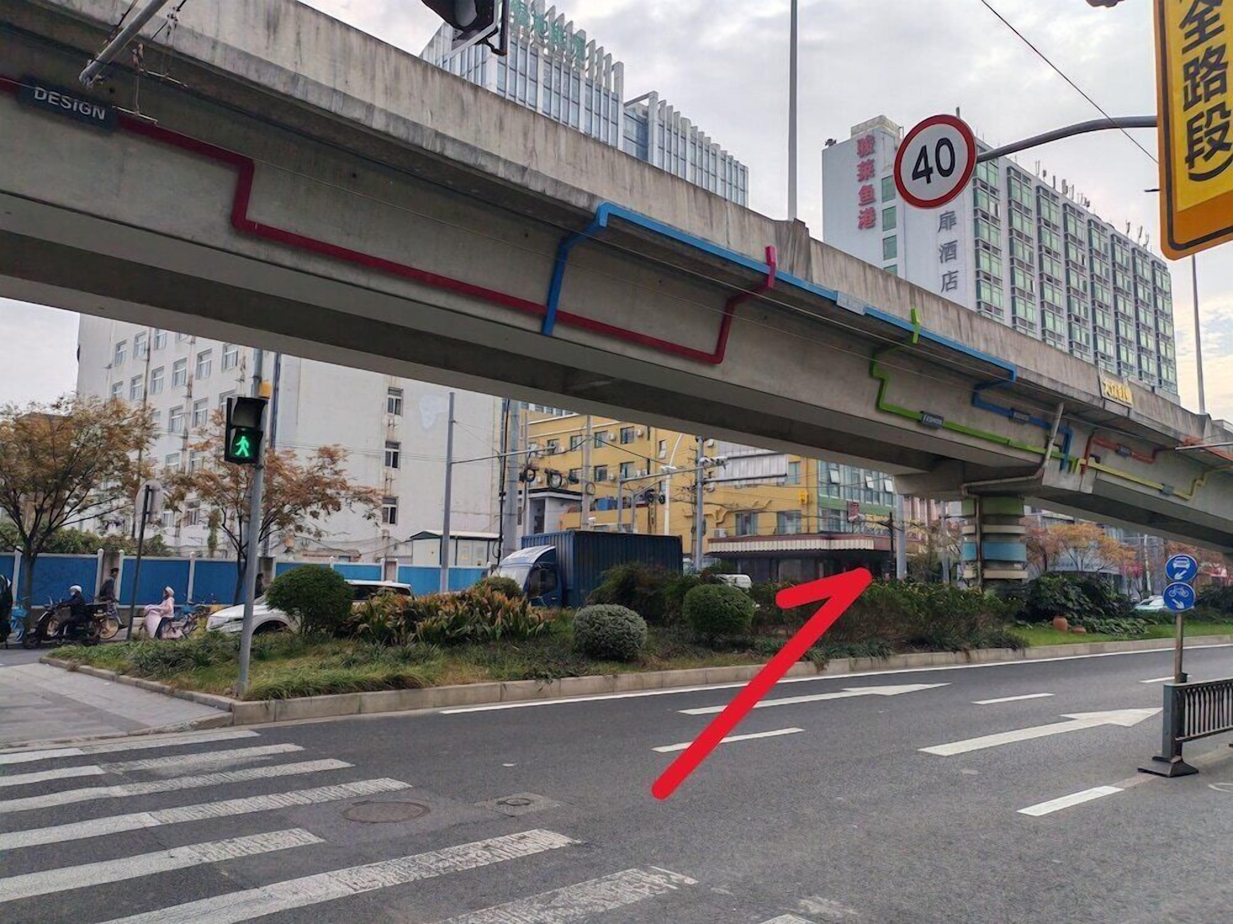 An urban street with a pedestrian crossing, a speed limit sign, and a directional arrow.