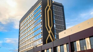 Un bâtiment moderne qui se distingue par un élément vertical marquant et une série de fenêtres.
