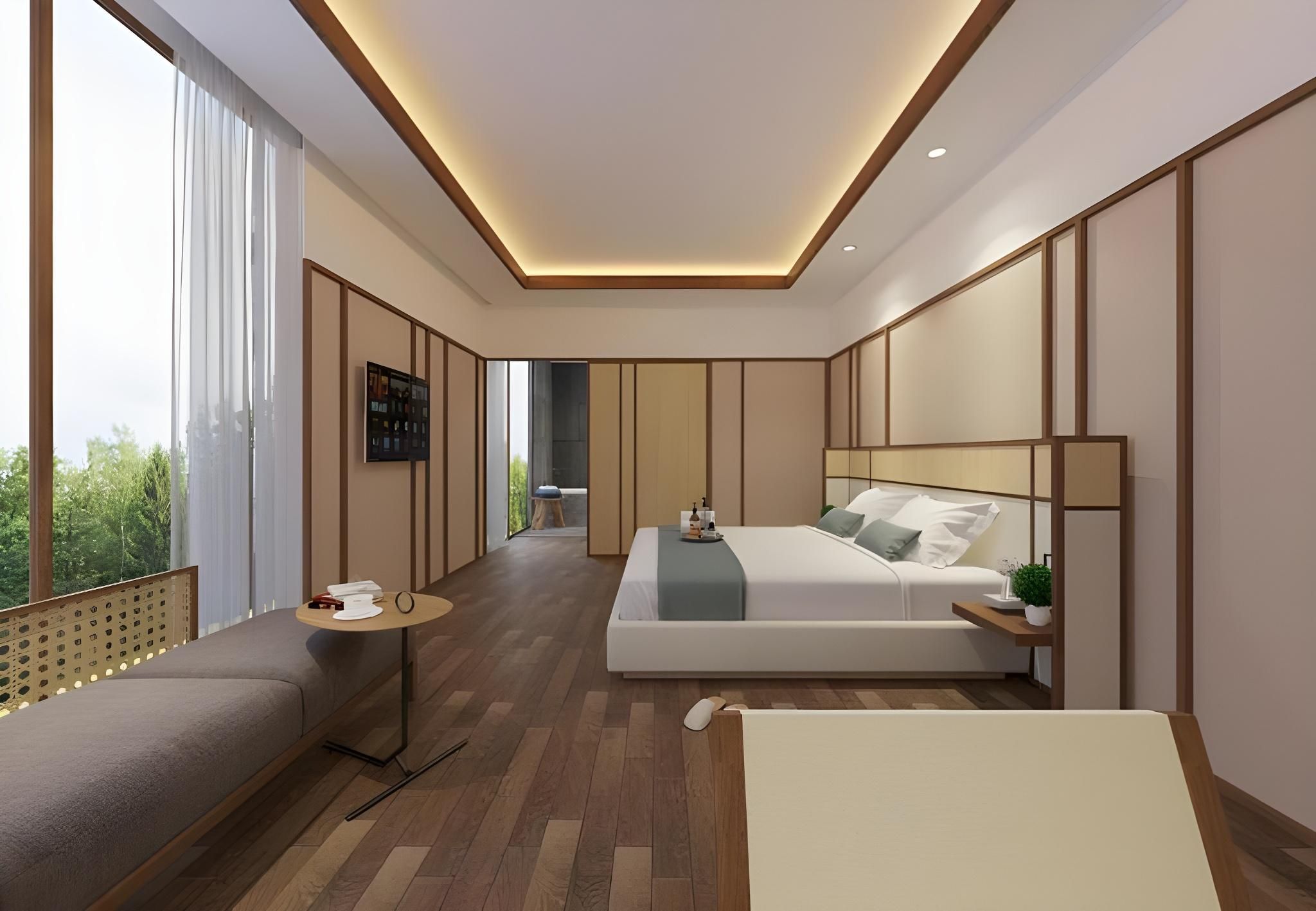 A modern bedroom with a large bed, a sitting area, and a view of greenery outside.