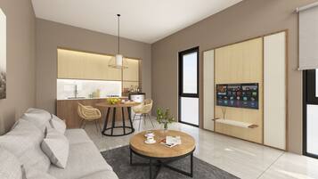 Een moderne woonkamer met een bank, een salontafel en een eethoek met stoelen, met een keuken op de achtergrond.