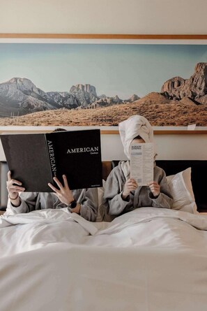 Two people reading books in a bedroom with a mountain view. - Tommie Austin (Austin)