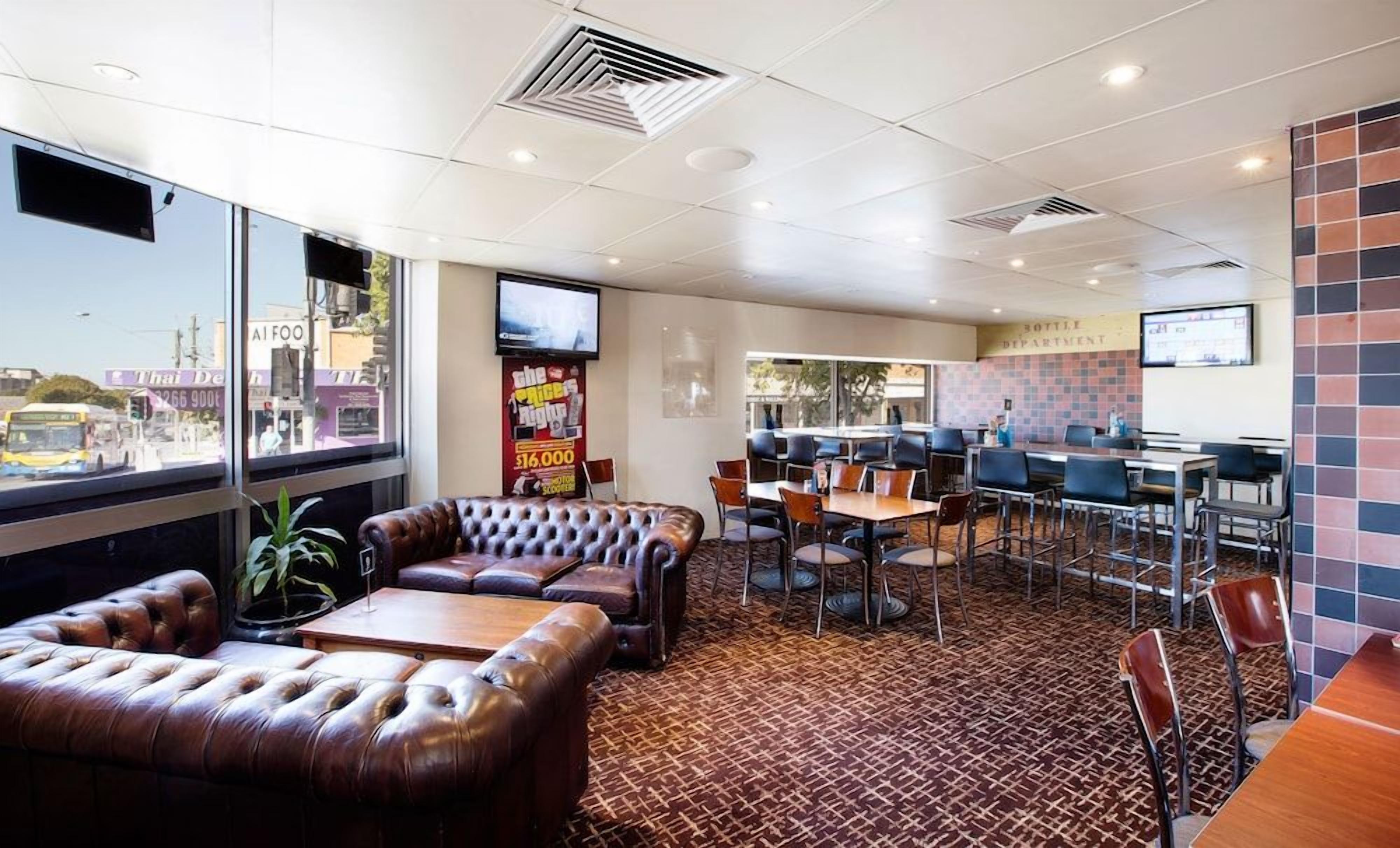 A restaurant with leather seating, a tiled floor, and a view of the street.