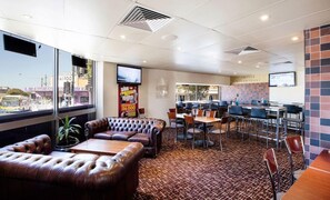 A restaurant with leather seating, a tiled floor, and a view of the street. - Prince of Wales Hotel (Brisbane)