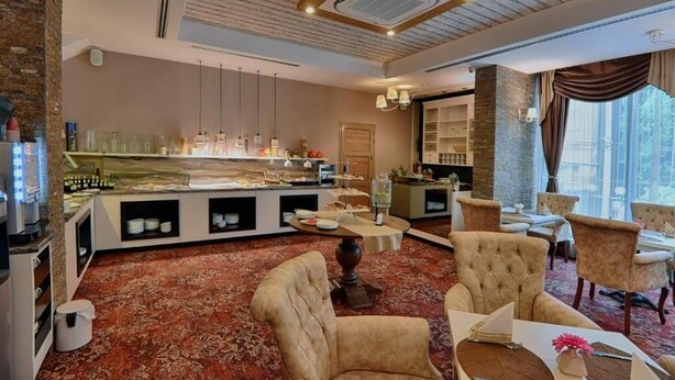 Un hall d’hôtel comprenant un espace buffet, des coins salon et une grande fenêtre offrant une vue panoramique.