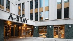 A modern hotel exterior with a prominent 'A-STA' sign, large glass doors, and a well-lit entrance area. - A-stay Antwerp (Antwerp)