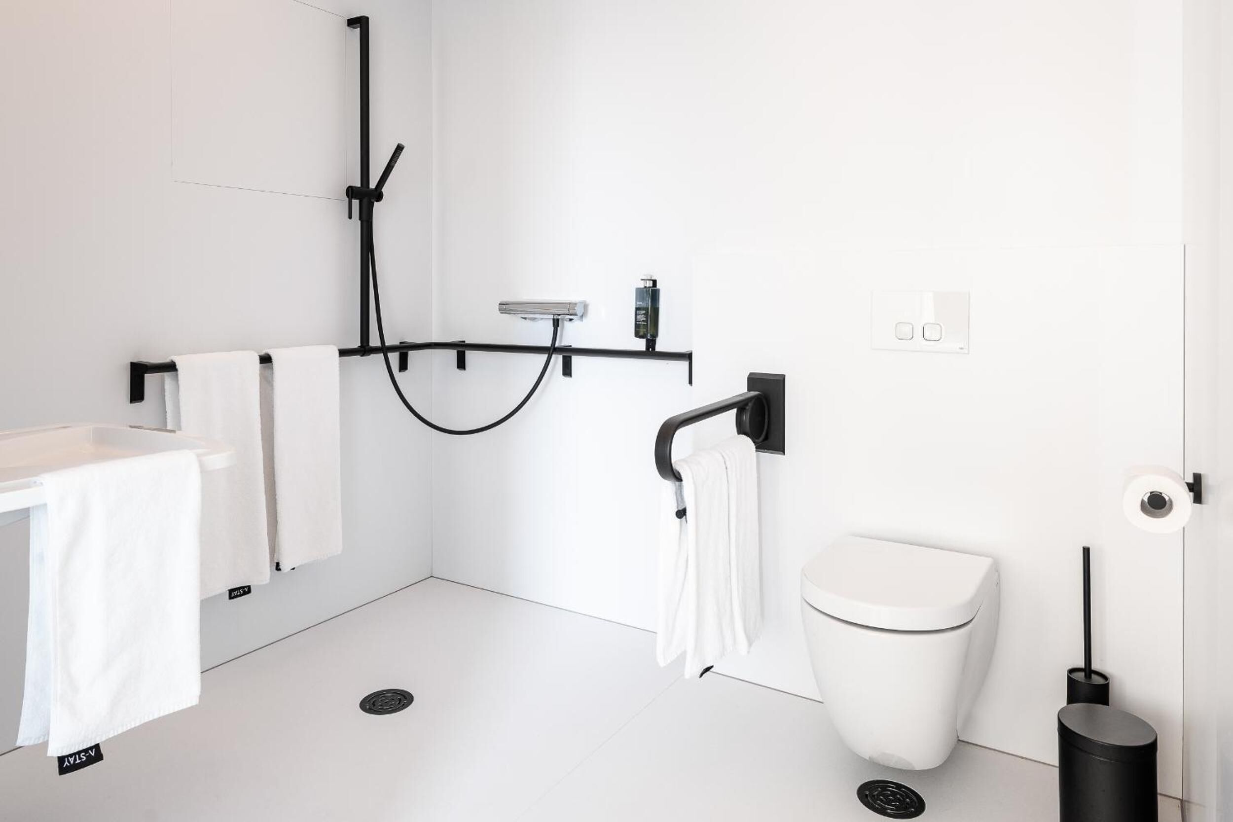 A modern bathroom with a toilet, bidet, and shower.