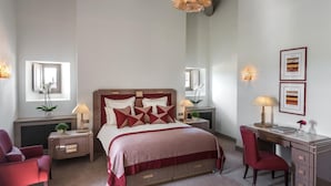 A bedroom with a large bed, bedside tables, a desk, and a chair. There are two wall-mounted lamps and a ceiling light. - Chateau Lafaurie-peyraguey by Lalique (Bommes)