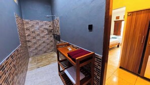 A small bathroom with a shower, a wooden bench, and a tiled floor. - Ketapang Guest House Canggu by Zuzu (Canggu)
