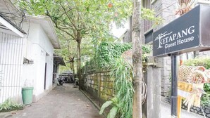 A narrow alleyway with a sign for 'KETAPANG Guest House' and a brick wall on one side. - Ketapang Guest House Canggu by Zuzu (Canggu)