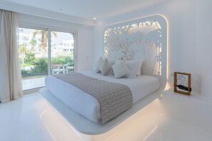 A modern bedroom with a large bed, a view of the outdoors, and a decorative wall panel. - Meraki Resort Sharm El Sheikh Adults and Couple Only) (Sharm El Sheikh)