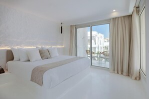 A modern bedroom with a large bed, a sliding glass door to a balcony, and a view of buildings. - Meraki Resort Sharm El Sheikh Adults and Couple Only) (Sharm El Sheikh)