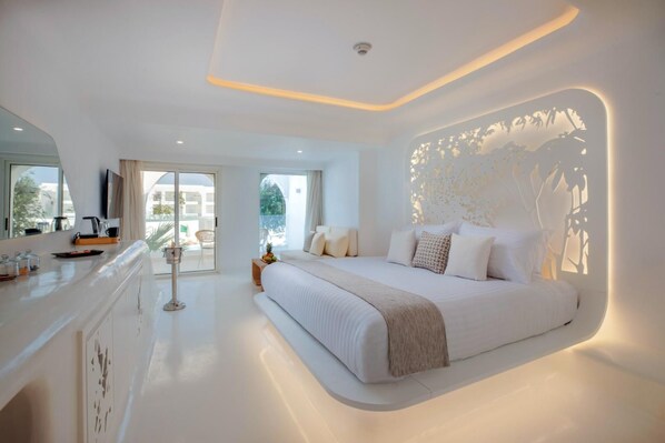 A modern hotel room with a large bed, a balcony with a view, and a kitchen area. - Meraki Resort Sharm El Sheikh Adults and Couple Only) (Sharm El Sheikh)