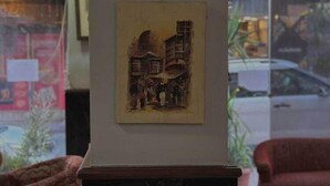 A lobby with a marble column, a framed artwork depicting a building, and a view of the street outside. - The Amman Pasha Hotel (Amman)