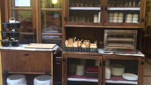 Een keuken met houten kastjes, een aanrecht en een fornuis. Er staan twee vuilnisbakken onder het aanrecht.
