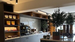 A modern kitchen with built-in shelves, a central island, and a large potted plant. - Hotel Gorinchem (Gorinchem)
