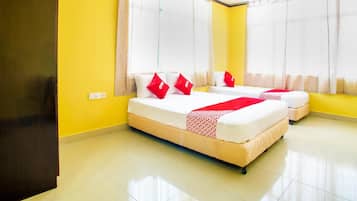 A hotel room with two beds, yellow walls, and large windows with sheer curtains.