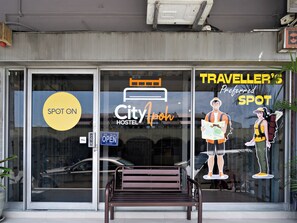 Une auberge de jeunesse avec une enseigne « SPOT ON », un logo « City Hostel » et une enseigne « TRAVELLER'S SPOT ».