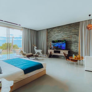A modern hotel room with a large bed, a TV, a stone wall, and a view of the sea. - Bavaro Beach Dakhla (Dakhla)
