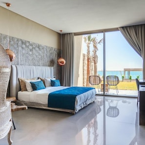 Un dormitorio moderno con cama, un ventanal grande y vista al mar.