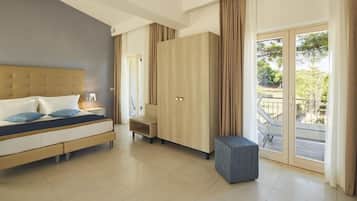 A modern bedroom with a bed, wardrobe, and a small seating area.
