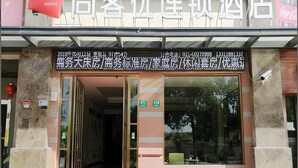 A hotel entrance with a signboard displaying room numbers and contact information. - Thank (Shanghai)