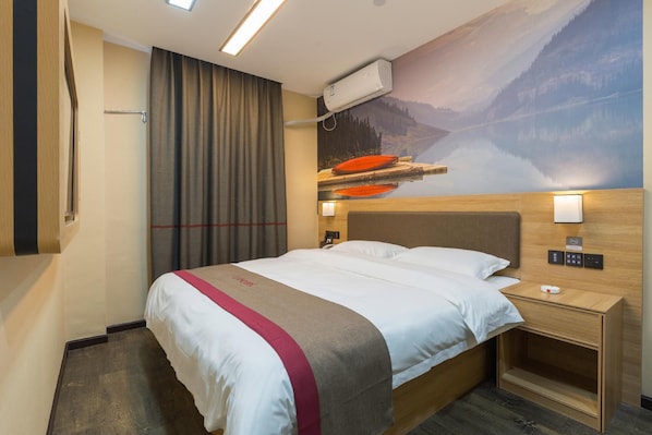 A hotel room with a bed, a nightstand, a wall-mounted air conditioner, and a large mural of a mountain landscape. - Thank (Shanghai)