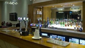A bar area with a long counter, multiple taps, and a variety of bottles. - Glenburn Hotel (Rothesay)