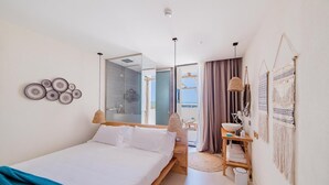 A modern bedroom with a bed, a vanity, and a bathroom visible through an open door. - Cumeja Beach Club Hotel (Cellole)